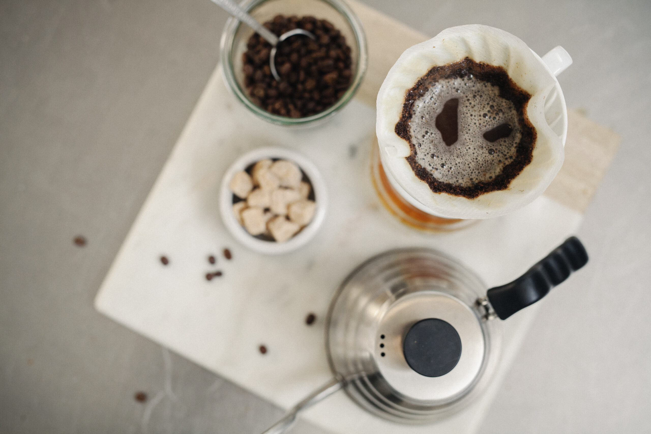 Making filter coffee. Overhead view of ground coffee, paper filter and sugar lumps.