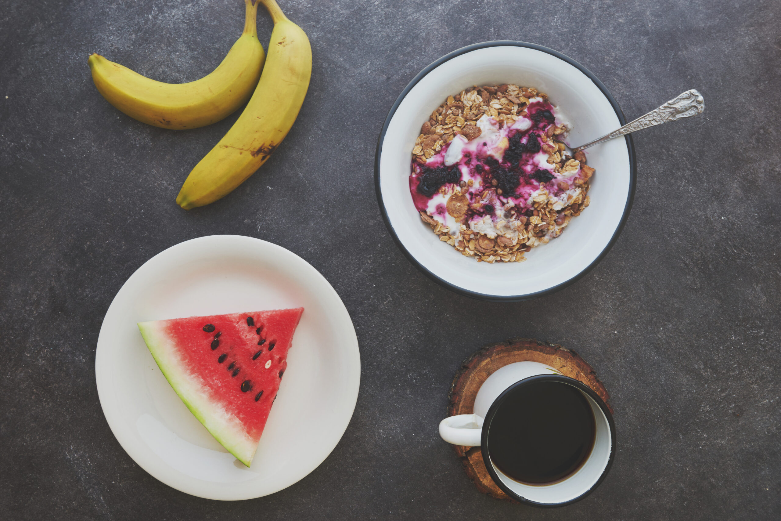 Breakfast with coffee and fruits on black cement background