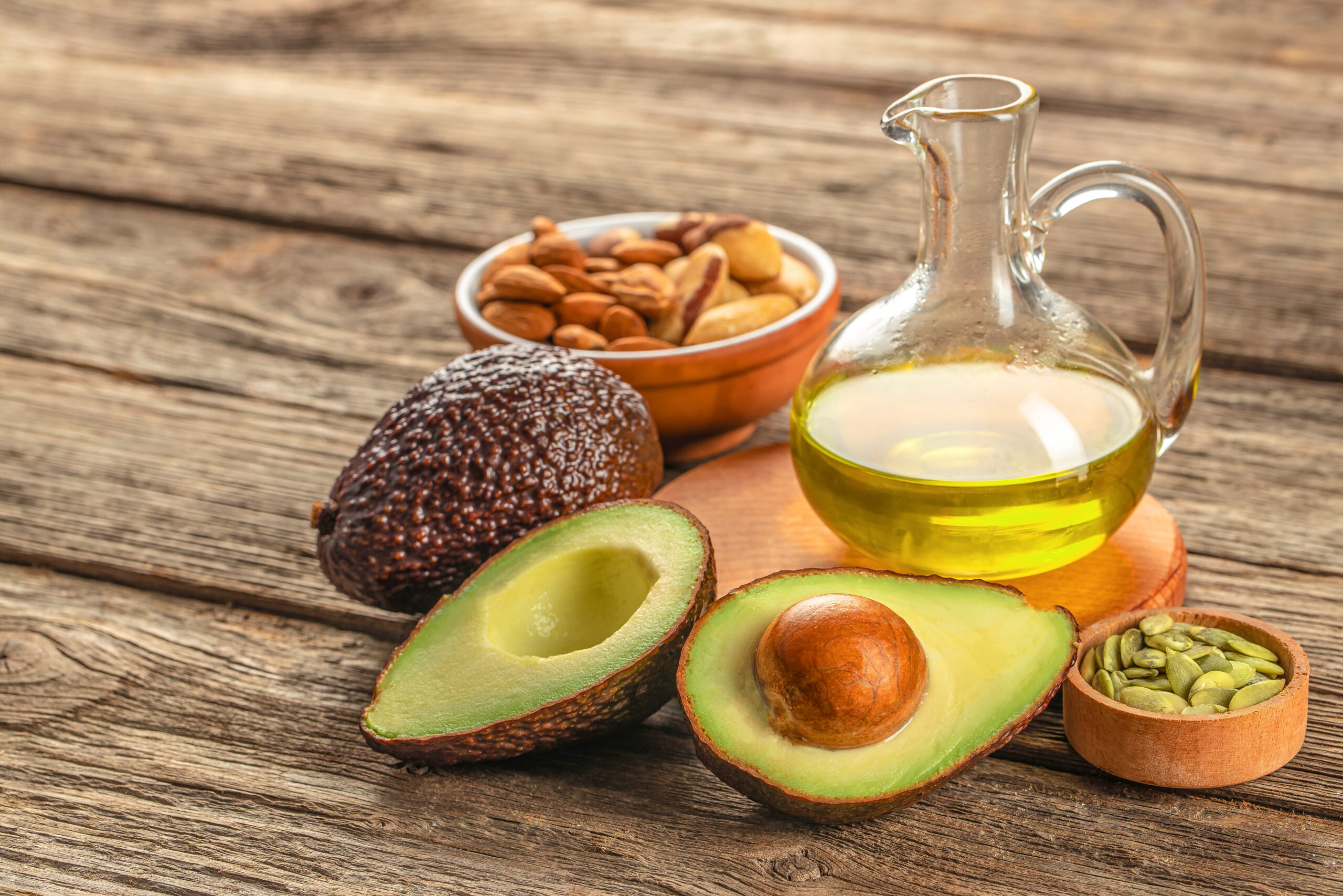 Healthy Fat avocado oil nuts on a wooden background. top view, omega 3, Vegan food,